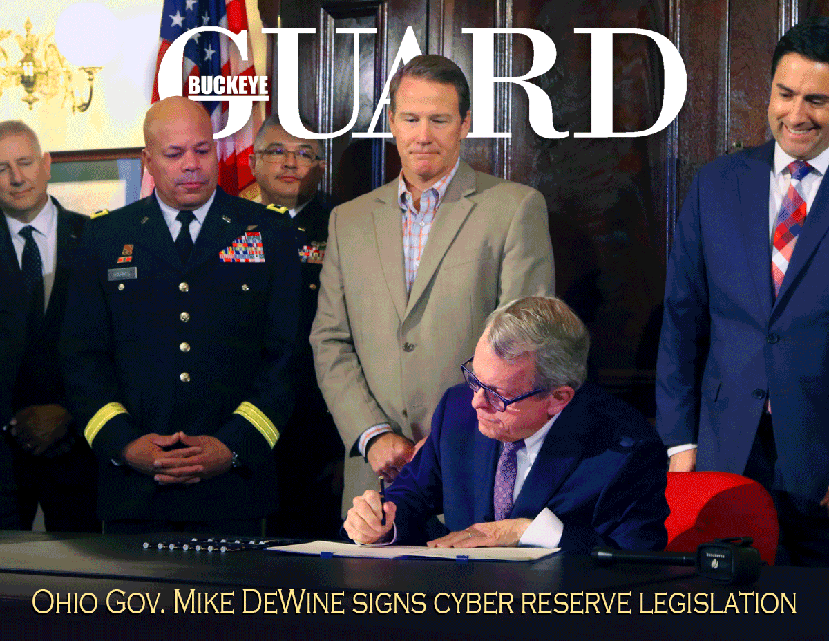 Cover of Buckey Guard online publication - Governor sits at desk signing while others stand around him.