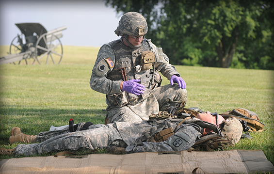 Staff Sgt. Dustin K. Hartman, a healthcare sergeant with the 285th Medical Company and an Alexandria, Ohio, native, evaluates his "casualty," Pfc. Robert L. O'Banion, an ambulance aide-driver with the 285th a Xenia, Ohio, native, during a class on tactical combat casualty care.
