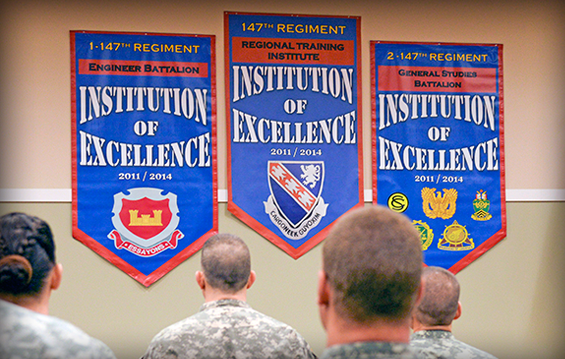 Soldiers of the 147th Regiment (Regional Training Institute) stand in formation as banners are unveiled to commemorate the RTI being named an Army Institution of Excellence.
