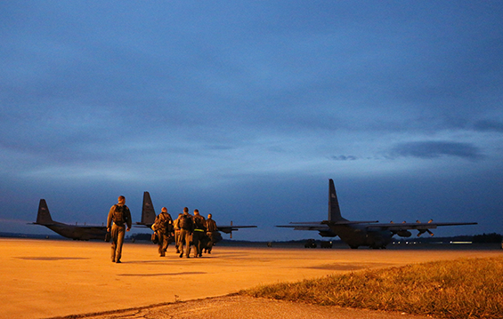 Members of a 164th Airlift Squadron aircrew head out onto the flight line to prepare for a C-130H Hercules night flying operation mission.