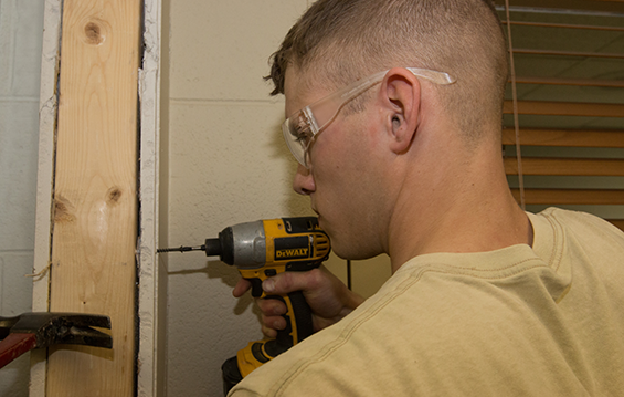 Staff Sgt. Jacob Murphy, a carpenter with the 200th Rapid Engineer Deployable Operational Repair Squadron Engineers (RED HORSE), frames out a new opening in a wall.