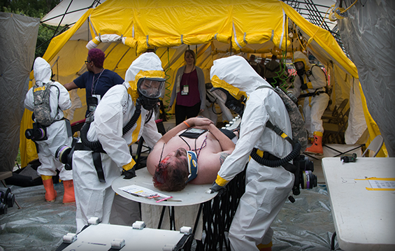 Members of the 637th Chemical Company move a simulated casualty through the decontamination tent during a training exercise.