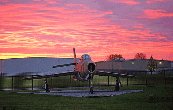 An early morning glow splashes a static display of an F-84 Thunderjet.