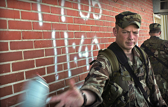 Sgt. Michael White tosses a can of spray paint back to another Soldiers after marking the building indicating it was clear. 