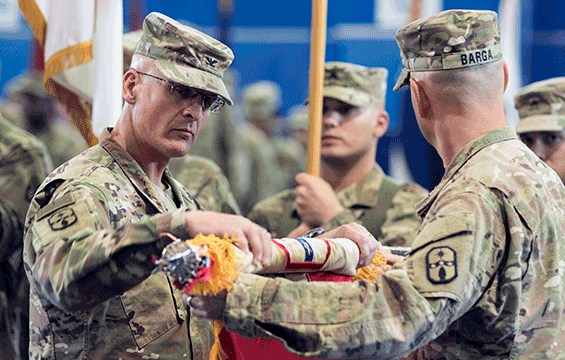 Col. Greg Betts, commander of the 371st Sustainment Brigade, and Command Sgt. Maj. Scott M. Barga, the brigade’s senior enlisted advisor, uncase the brigade colors. 