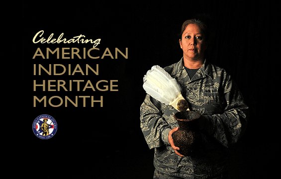 Master Sgt. Serena Dedes, an equipment manager at the 180th Fighter Wing, holds a traditional feather flag used during pow wows along with water vase handmade by her mother.
