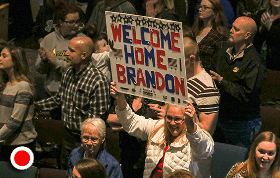 A Family member greets her Soldier with a ‘welcome home’ sign.