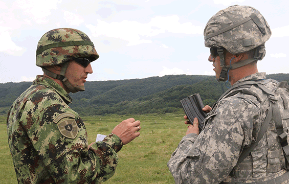 Serbian Armed Forces Maj. Goran Zivanovic (left) instructs Spc. Bane Dodson of the 37th Infantry Brigade Combat Team during a live-fire exercise.