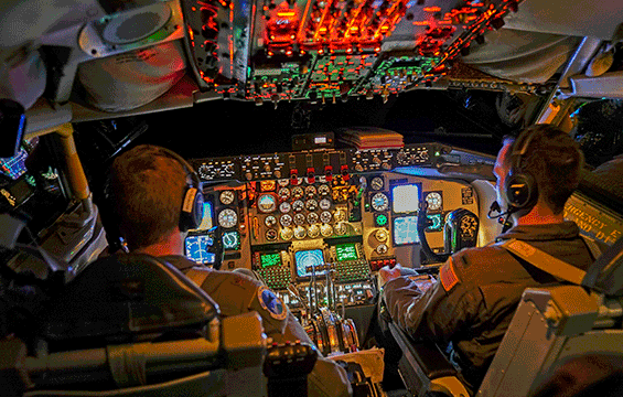 Pilots in the cockpit of a KC-135 at night.