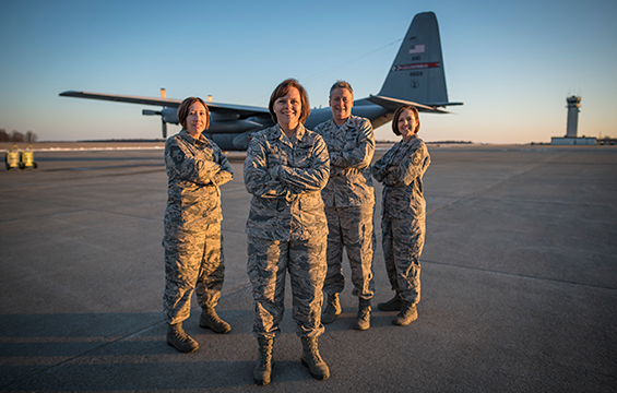 Four top ranking airmen (women) on airstrip with aircraft in background.