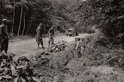 Soldiers from Company C, 112th Engineer Battalion on road maintenance through Forest de Cerisy, Normandy, June 26, 1944.