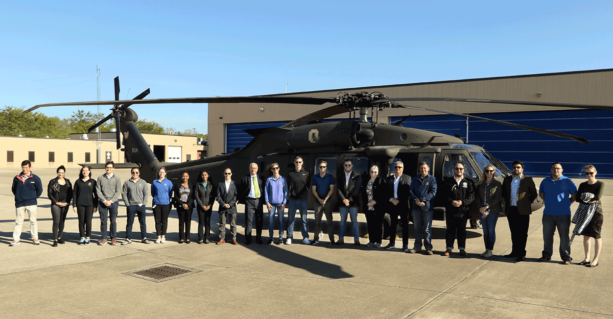 Group stand in front of a Black Hawk.