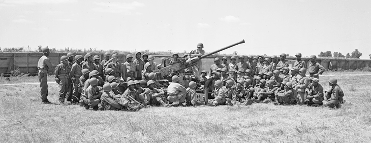 Soldiers from the 137th AAA Bn. receive a class on a 40 mm anti-aircraft gun. 