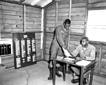 Pvt. Lipkin shows paper work to Cpt. James B. Payne of the 137th AAA Bn. 