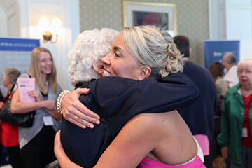 Amanda Wirtz (right), a Navy combat veteran and motivational speaker, embraces Dorothy Wolfe