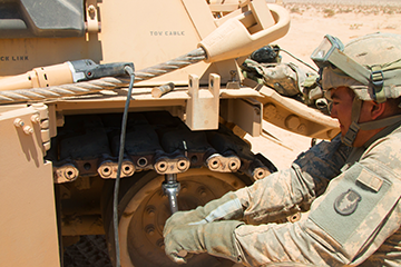 A Soldier with the 1st Battalion, 145th Armored Regiment tightens the track linkage on an M88 Hercules recovery vehicle.