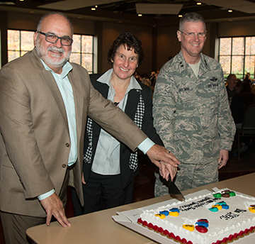 Mike Magnusson (from left), a transition assistance advisor for the Ohio National Guard, Julie Blike, director of ONG Family Readiness and Warrior Support, and Maj. Gen. Mark E. Bartman, Ohio adjutant general, prepare to cut a cake.
