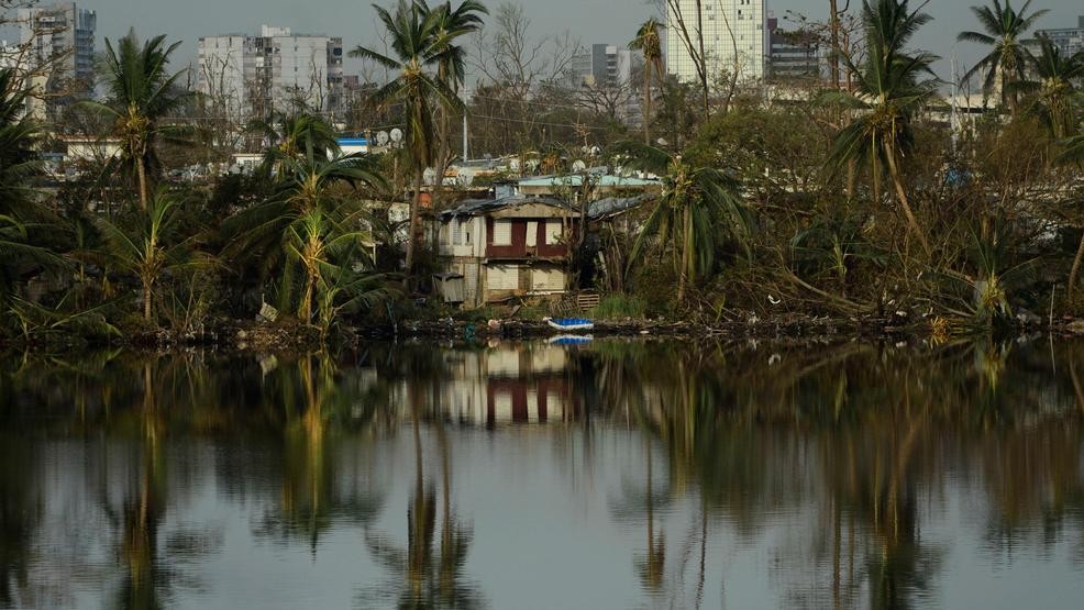 Trees are reflected in the water in the Buena Vista community in the aftermath of Hurricane Maria in San Juan, Puerto Rico, Sunday, Sept. 24, 2017. 