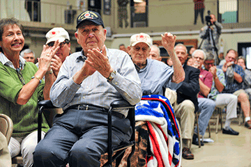 Veteran appaluded by audience for service.