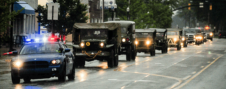 Emergency and historic military vehicles lead the funeral procession for Technician 4th Grade John Kovach Jr.