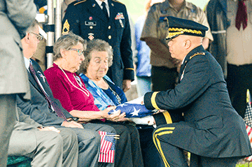 Maj. Gen. John C. Harris Jr., Ohio assistant adjutant general for Army, presents a folded American flag to Mary Ocheske during graveside services for her brother, Technician 4th Grade John Kovach Jr. 