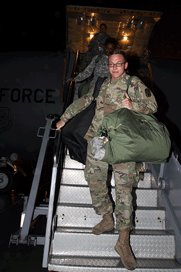 Pfc. Kyle McKay, an information technology specialist with the 137th Signal Company, disembarks from a KC-135 Stratotanker