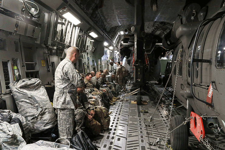 Inside loaded C-17 Globemaster III with two Blackhawks and Guard members.