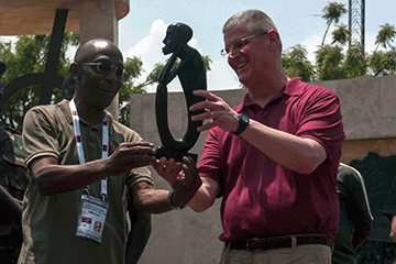 MG Mark E. Bartman holds up artifact with local dignitary