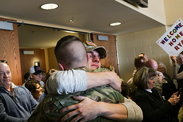 Soldier getting hug from loved one.