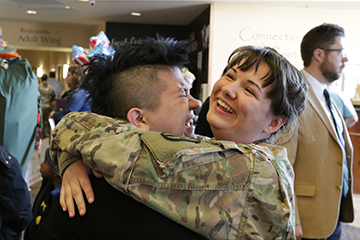 Female soldier getting hug from loved one.