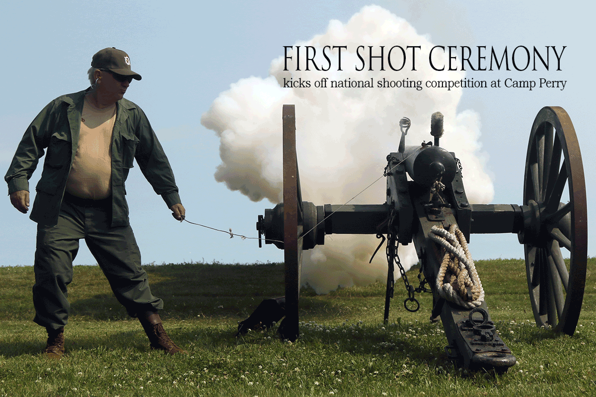 Man fires antique cannon with white smoke trailing up to blue skies.