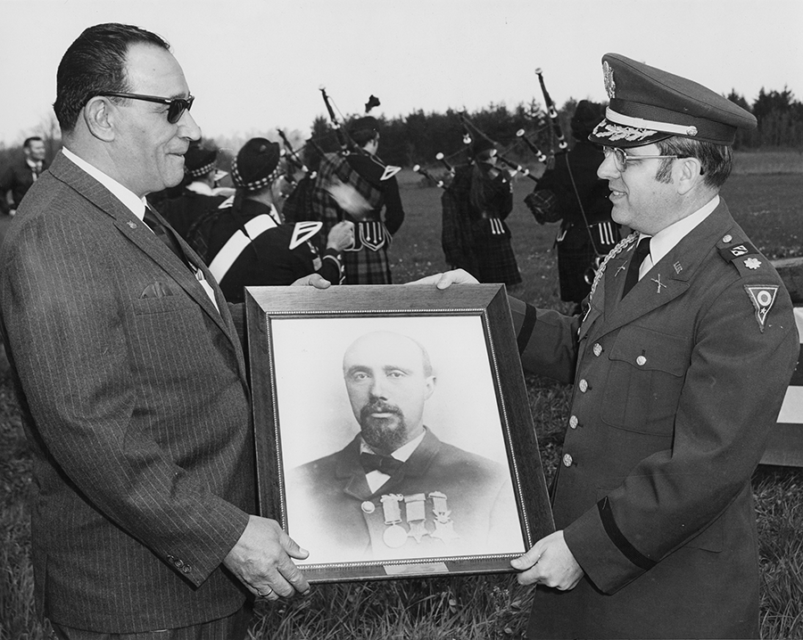 Man hands protrait to Lt. Col.