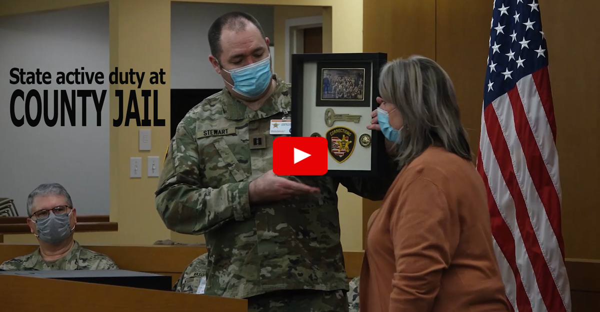 Woman presents Soldier with plaque.
