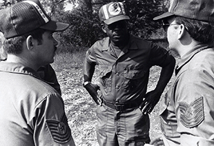 Tech. Sgt. Gibson (center) of the 200th RED HORSE Squadron confers with fellow noncommissioned officers during a training mission, circa 1970s