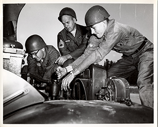 Pvt. Werner B. Schmidt (left) and Spc. 4 Roger A. Rine (right) receive instruction on engine tune-up from Sgt. 1st Class Paul E. Robinson, 737th Maintenance Battalion, circa 1960s.