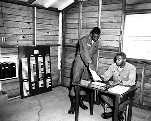 Pvt. Lipkin (left) shows paperwork to Capt. James B. Payne of the 137th Anti-Aircraft Artillery Battalion, Camp Perry, Ohio, circa 1950s. 