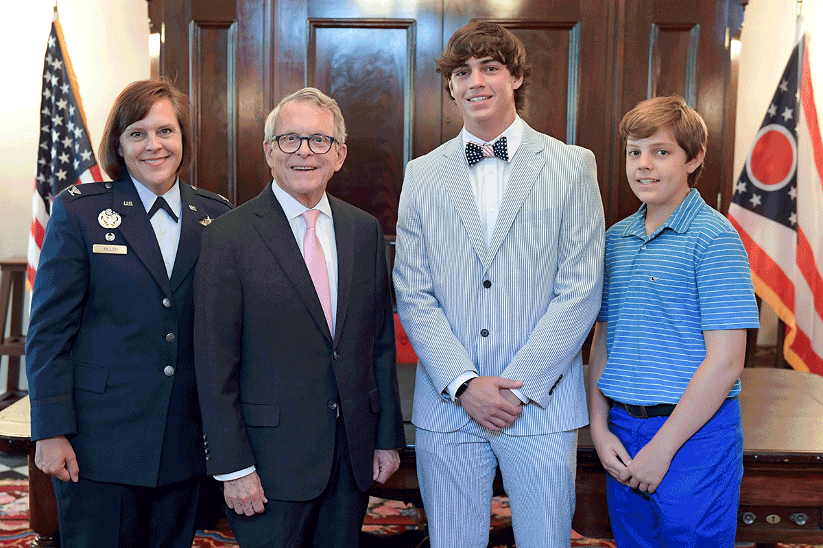 Military child of the year, and family stands with Mayor DeWine .