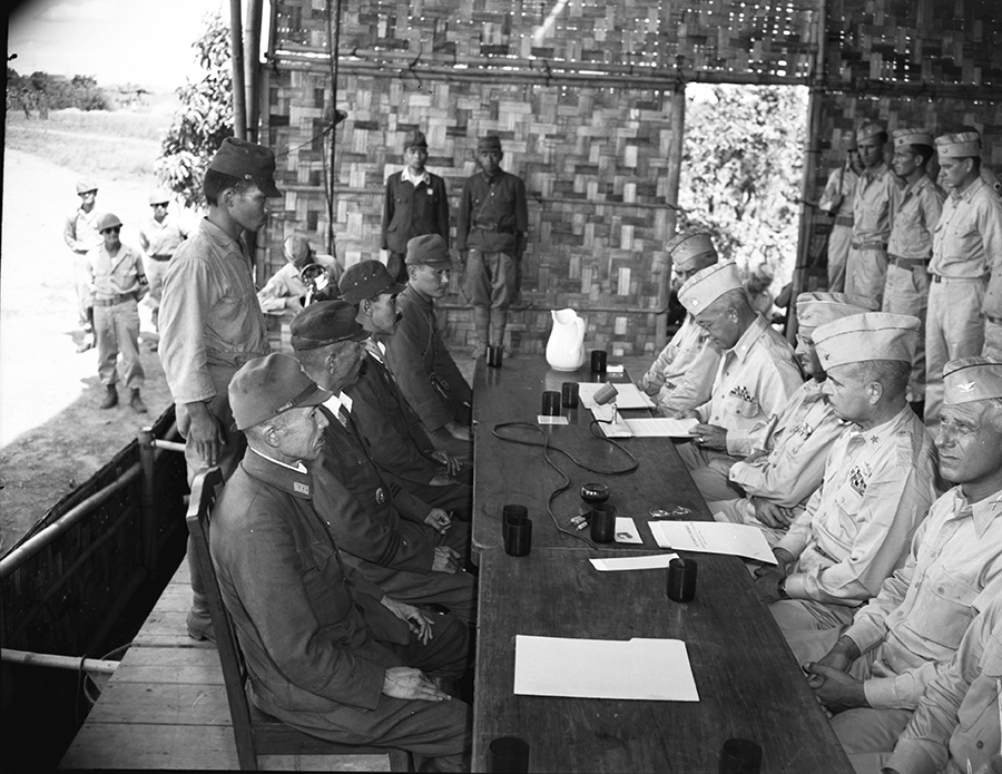 U.S. official at table with Japanese officials to sign treaty.