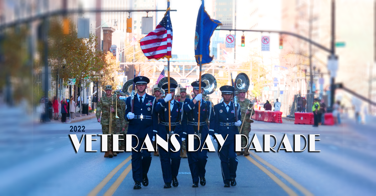 Color guard carries flags in street.