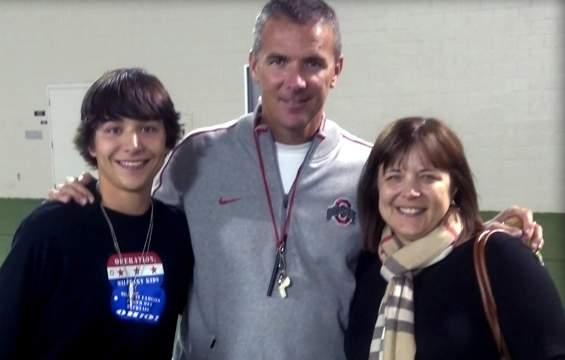 Joel Rieck, son of Master Sgt. Jeffrey J. Rieck, who died April 4, 2012, while serving during Operation Enduring Freedom, gets his picture taken with Ohio State head football coach Urban Meyer and his mother, Catherine Gromacki Rieck,