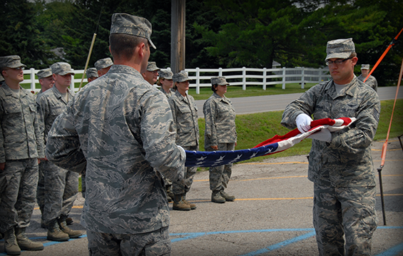 Second Lt. Peter Herrmann (left) and Tech. Sgt. Benjamin Marshall, both of the 126th Intelligence Squadron, Ohio Air National Guard, located in Springfield, Ohio, fold a flag during a flag retirement ceremony July 31, 2013, in Alpena, Mich. 