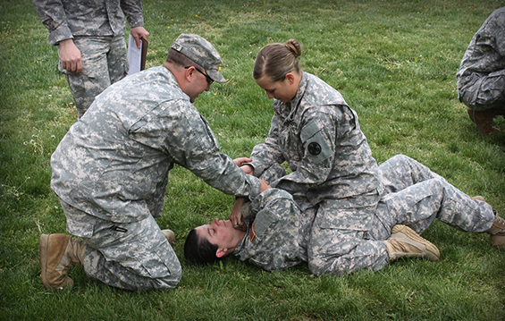 Sgt. David Bradford (left) instructs Pfc. Courtney Lutz (top) and Spc. Jodelana Birchfield of the 1194th Engineer Company on combatives techniques