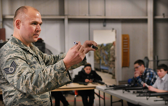 Staff Sgt. Derek Kania, a combat arms training and maintenance instructor, shows new 180th Fighter Wing recruits how to disassemble the bolt of an M-16 rifle 