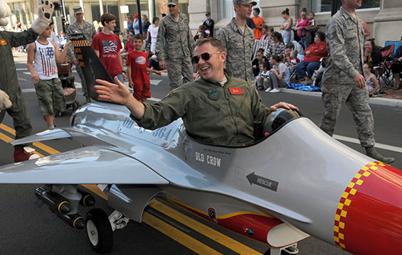 Members of the 178th Fighter Wing march with the unit's F-16 Fighting Falcon mini jet 