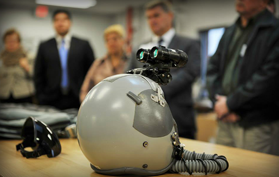 An F-16 Fighting Falcon pilot's helmet sits on display in front of members of the Toledo Regional Chamber of Commerce