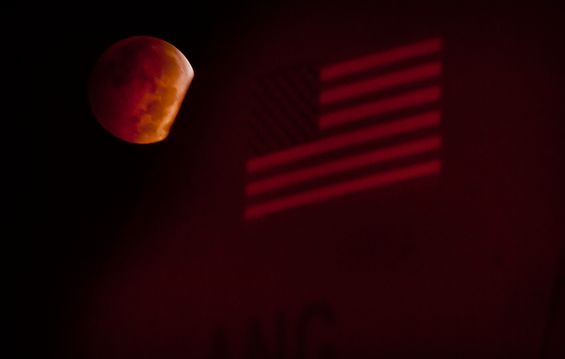 A total lunar eclipse is visible behind the tail fin of one of 121st Air Refueling Wing's KC-135R Stratotankers.