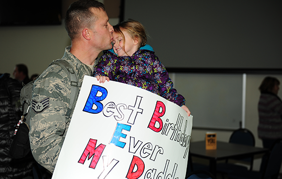 Staff Sgt. Jeremy Behnfeldt sees his daughter for the first time in over six months, on her 3rd birthday, Feb. 2, 2015, during a homecoming for members of the 180th Fighter Wing Security Forces.