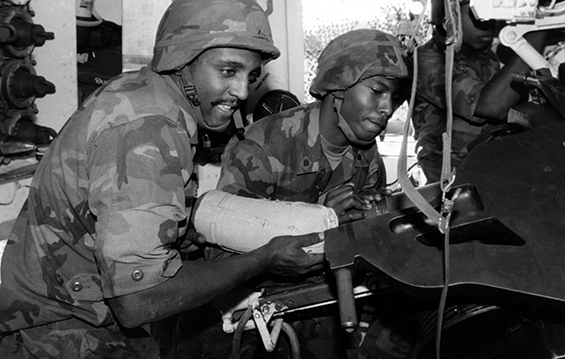 ONG celebrates African-American/Black history month:  Pfc. Paul H. Norton Jr. (left) loads a bag of powder charge into the tube of a M109 Self-Propelled Howitzer while Spc. Gregory C. Jones holds the round out of the way during annual training in 1988