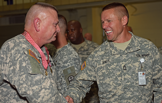 Col. Michael Ore (left) is congratulated on his retirement by Master Sgt. William Knox.