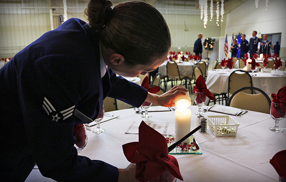 Senior Airman Bri Oswalt helps prepare tables as members of the 179th Airlift Wing gather to honor nominees at the wing's Airmen of the year banquet.